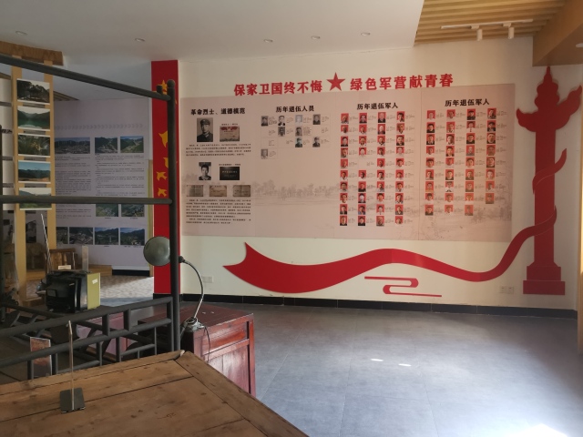 一面写着"保家卫国终不悔 绿色军营献青春"红色标语的"军人荣誉墙"